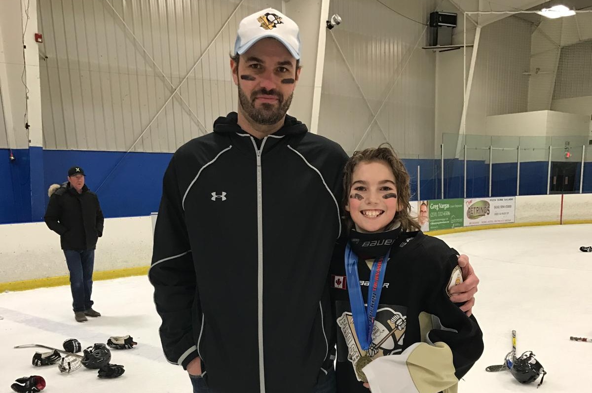 Joel Rowswell with a young hockey player on the ice